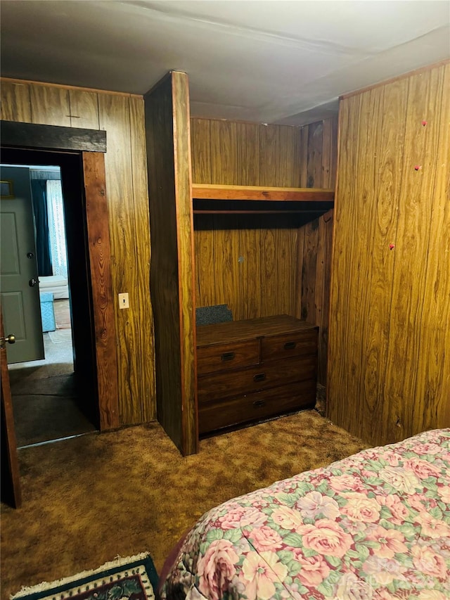 carpeted bedroom featuring wooden walls