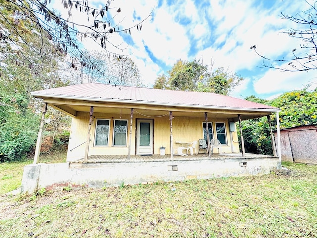 rear view of property featuring a lawn and a porch