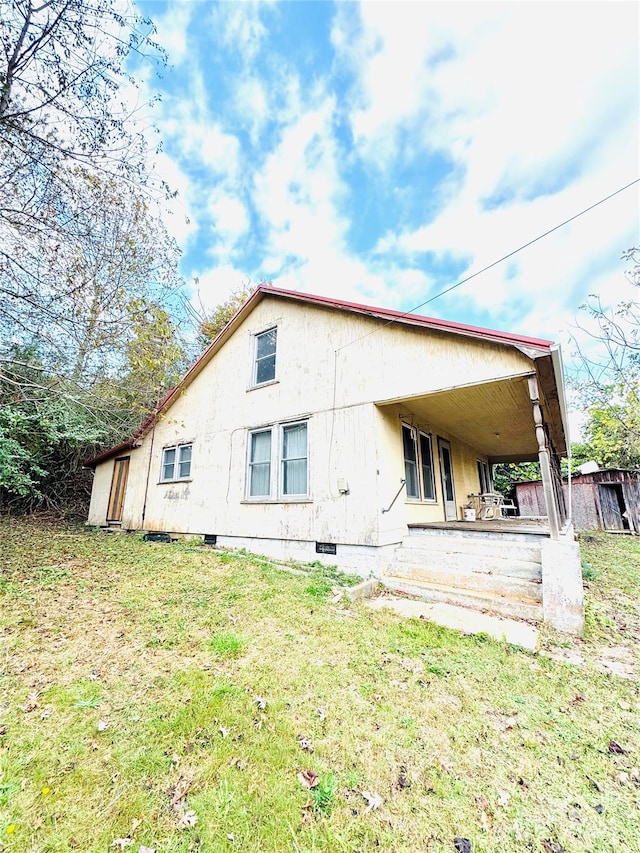 rear view of property featuring a patio and a yard