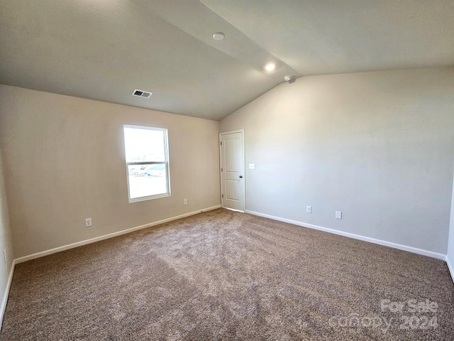 unfurnished room featuring carpet floors and vaulted ceiling