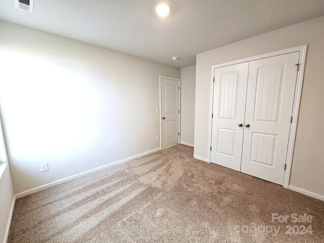 unfurnished bedroom with carpet and a closet