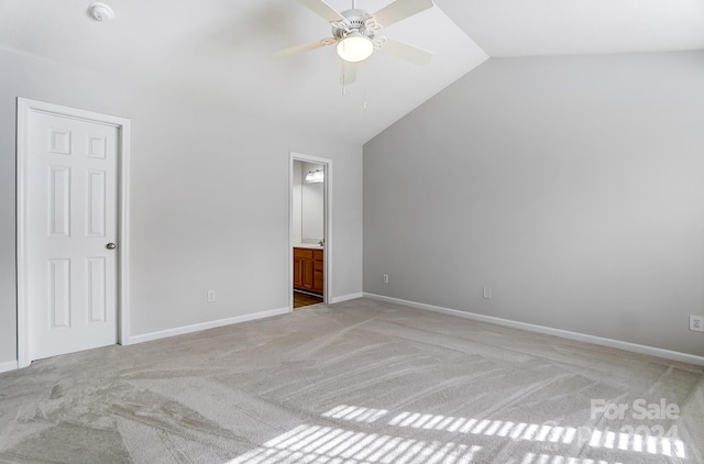 unfurnished bedroom with carpet, ceiling fan, connected bathroom, and vaulted ceiling