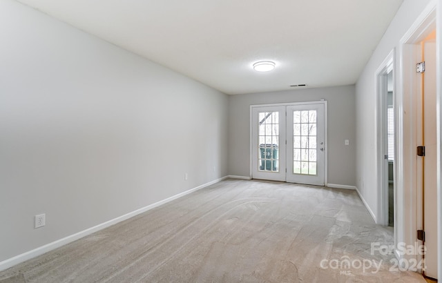 carpeted empty room featuring french doors