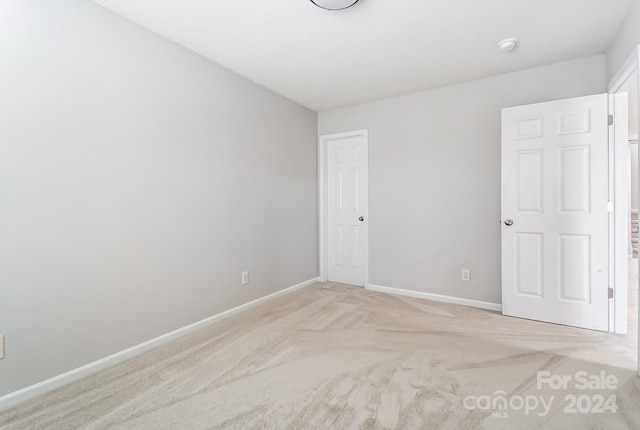 spare room featuring light colored carpet