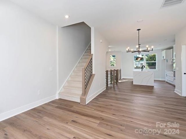 interior space featuring wood-type flooring, sink, and an inviting chandelier