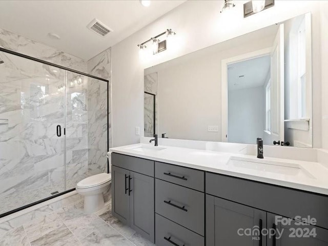 bathroom with vanity, a shower with shower door, and toilet