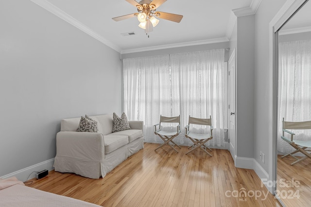 living room with crown molding, visible vents, and wood finished floors