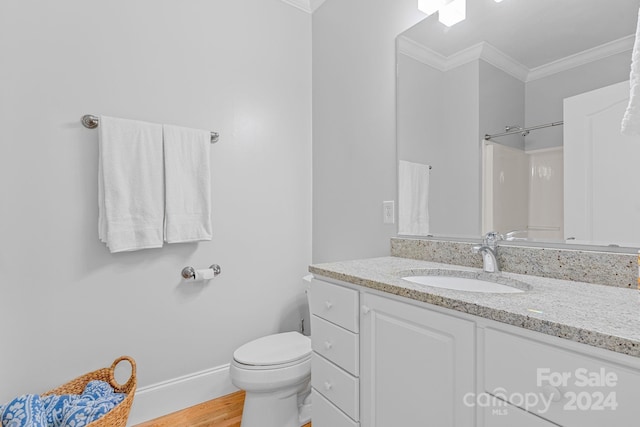 bathroom with baseboards, a shower, toilet, ornamental molding, and vanity