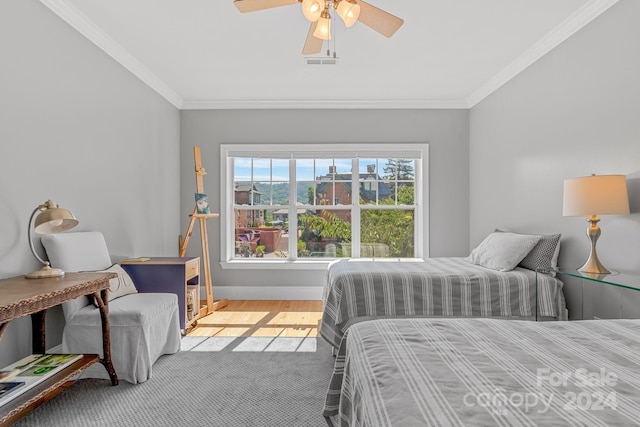 bedroom with visible vents, baseboards, a ceiling fan, light wood-type flooring, and crown molding