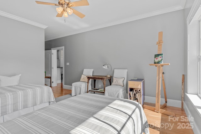 bedroom featuring baseboards, ornamental molding, light wood-style flooring, and a ceiling fan