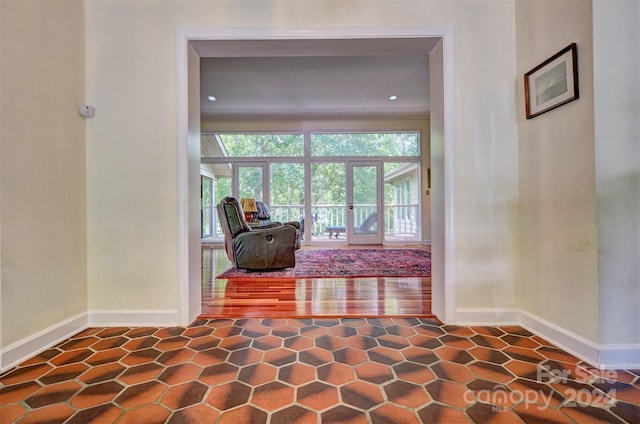 hall with a healthy amount of sunlight and dark hardwood / wood-style floors