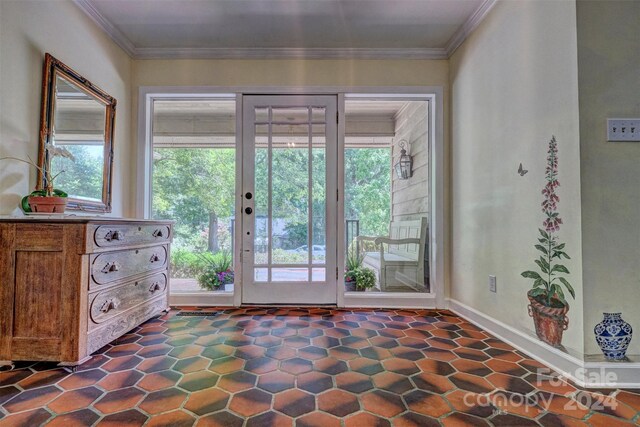 entryway featuring dark tile patterned floors and ornamental molding