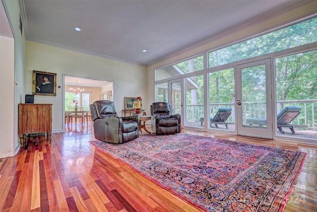 living room with crown molding, hardwood / wood-style flooring, and a notable chandelier