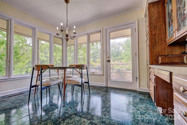 sunroom / solarium featuring a chandelier