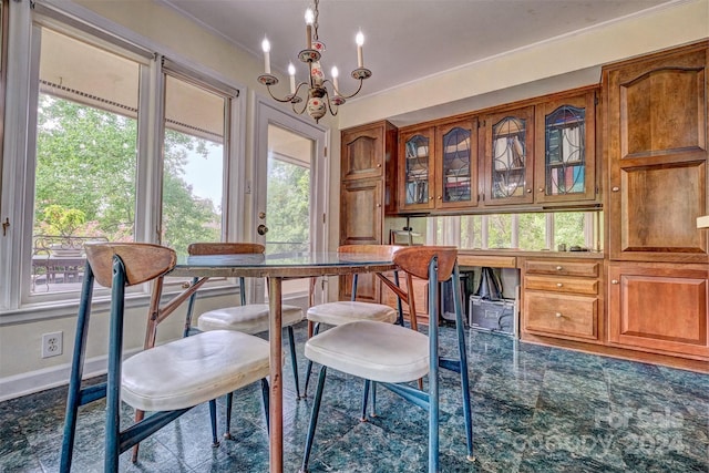 tiled dining area featuring a notable chandelier, ornamental molding, and plenty of natural light