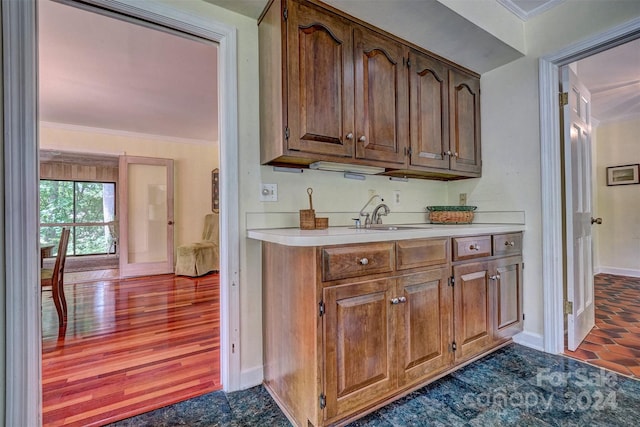 kitchen with ornamental molding, sink, and dark hardwood / wood-style floors