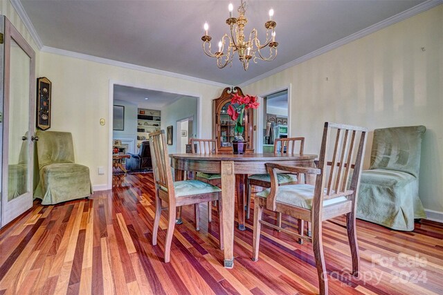 dining room featuring crown molding, hardwood / wood-style floors, and a chandelier