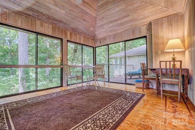 interior space with a healthy amount of sunlight, wood walls, light wood-type flooring, and wooden ceiling