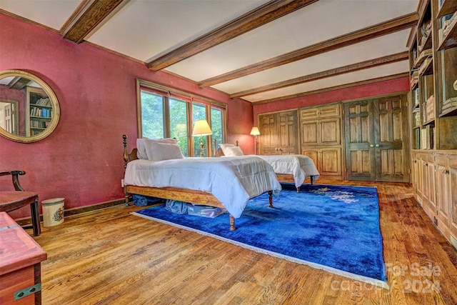 bedroom featuring beamed ceiling and hardwood / wood-style flooring