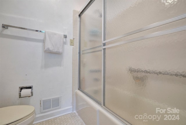 bathroom featuring enclosed tub / shower combo and toilet