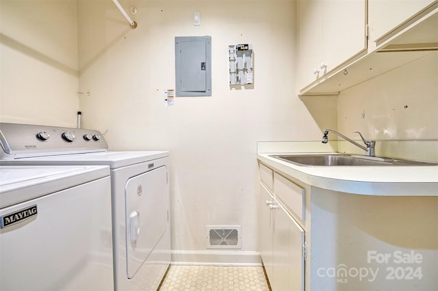 laundry area with washing machine and clothes dryer, cabinets, electric panel, and light tile patterned floors