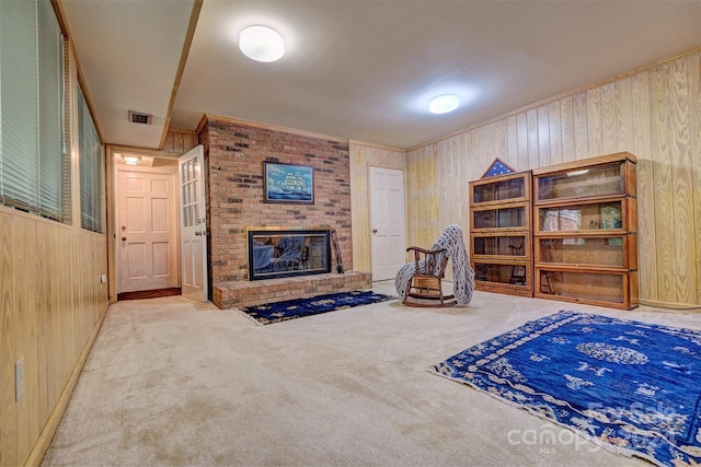 interior space featuring a brick fireplace, ornamental molding, light colored carpet, and wood walls