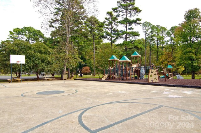 view of basketball court featuring a playground