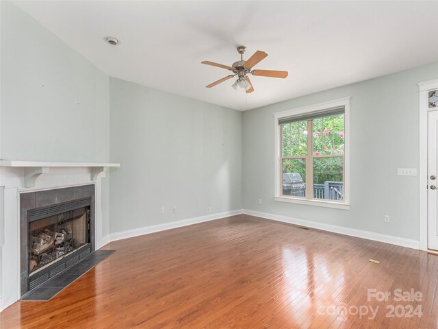 unfurnished living room featuring ceiling fan, a fireplace, and hardwood / wood-style flooring