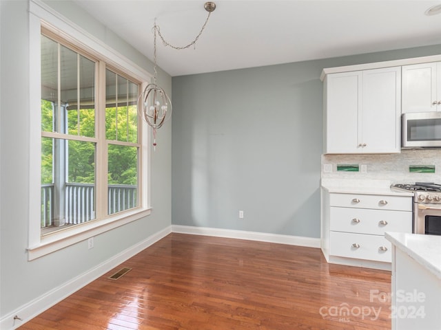 unfurnished dining area with a chandelier and light hardwood / wood-style flooring