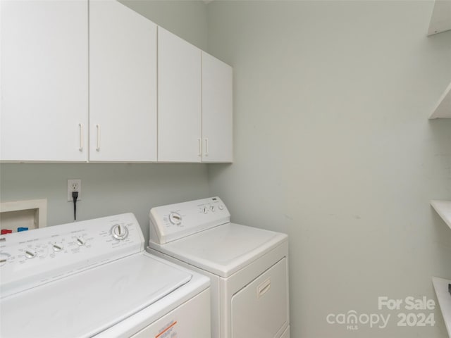 laundry room with separate washer and dryer and cabinets