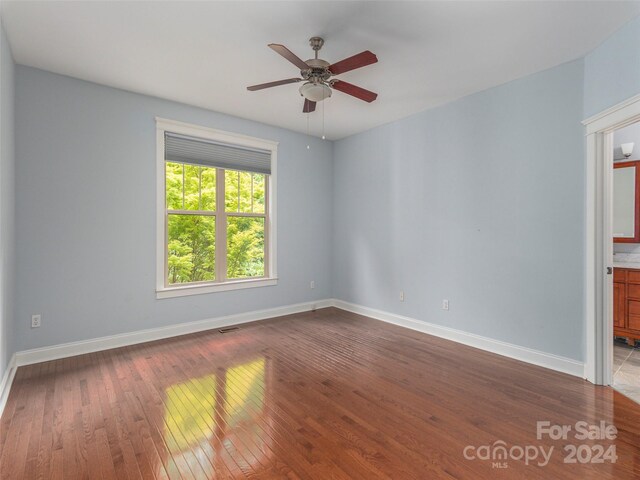 empty room with hardwood / wood-style floors and ceiling fan