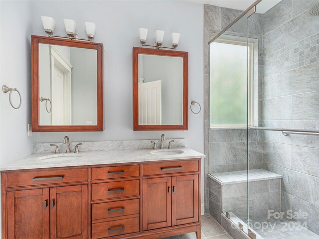 bathroom featuring an enclosed shower and double sink vanity