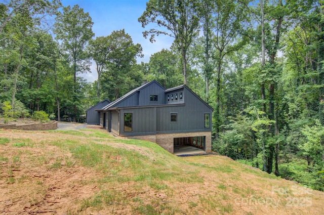 back of property with a carport and a yard