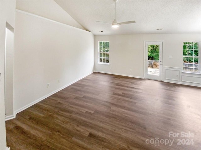 empty room featuring dark wood-type flooring, a textured ceiling, lofted ceiling, and ceiling fan