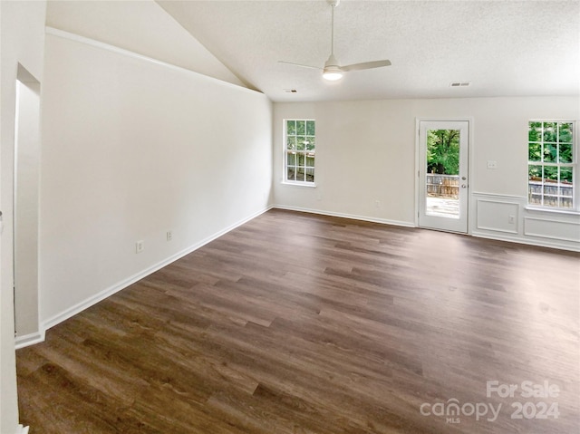 unfurnished room featuring lofted ceiling, dark hardwood / wood-style floors, a wealth of natural light, and ceiling fan