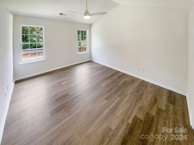 empty room featuring vaulted ceiling, a textured ceiling, ceiling fan, and hardwood / wood-style floors