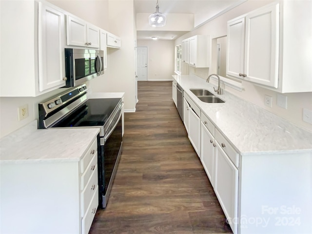 kitchen with stainless steel appliances, white cabinets, sink, hanging light fixtures, and dark hardwood / wood-style flooring