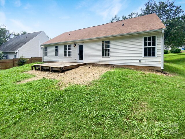 rear view of property with a deck and a yard