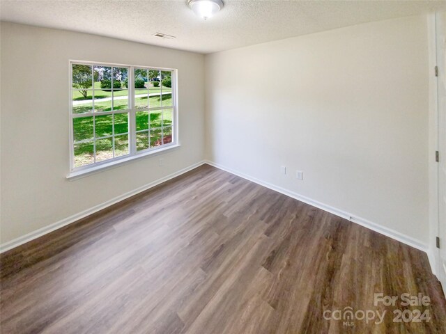 spare room featuring a textured ceiling and wood-type flooring