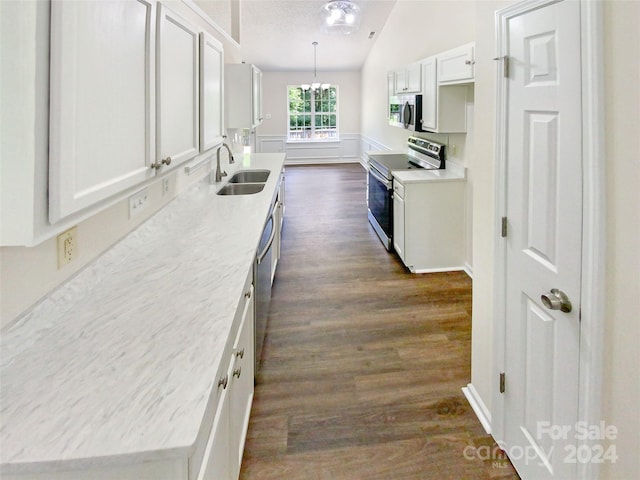 kitchen featuring lofted ceiling, a notable chandelier, dark wood-type flooring, appliances with stainless steel finishes, and sink