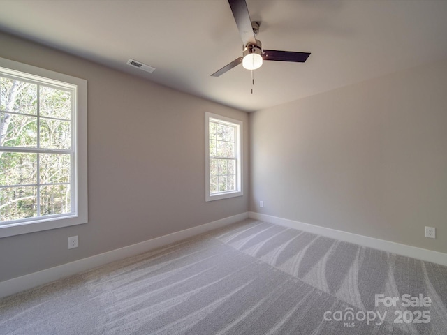 carpeted empty room featuring a healthy amount of sunlight and ceiling fan