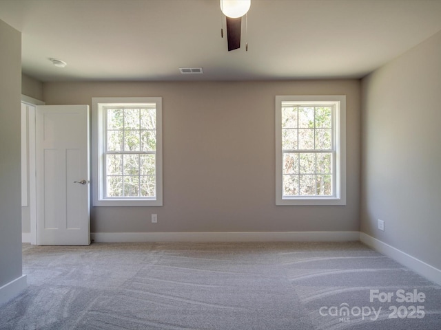 carpeted spare room with plenty of natural light and ceiling fan