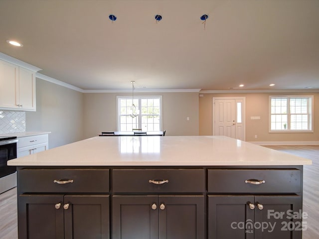 1133 Heather Oak Ln, Oakboro, NC 28129 - kitchen featuring electric range, white cabinets, light wood finished floors, light countertops, and a kitchen island