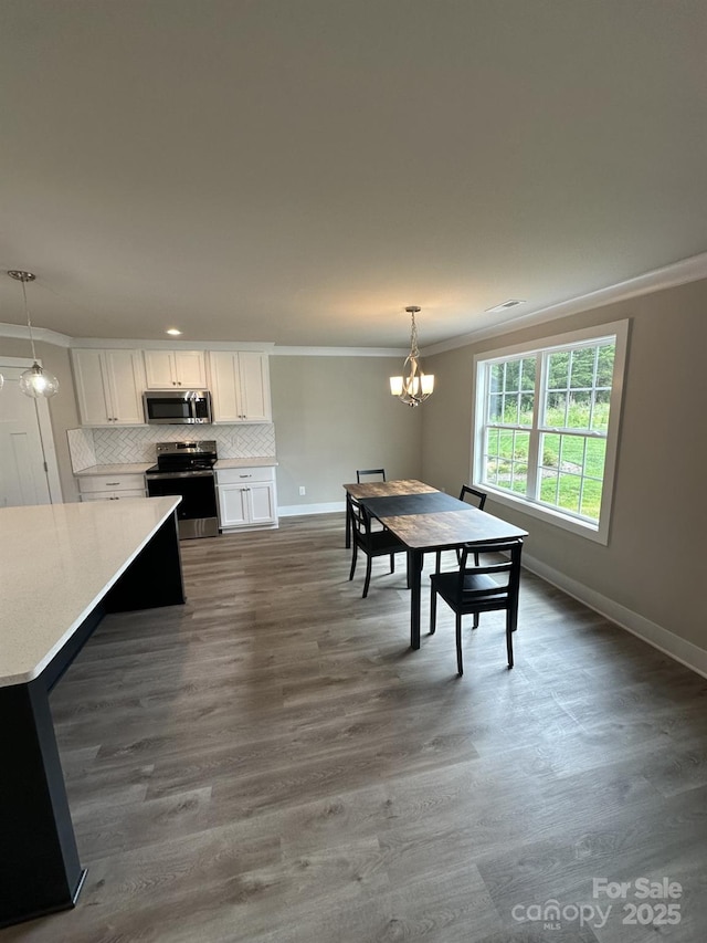 1133 Heather Oak Ln, Oakboro, NC 28129 - dining space with crown molding, a chandelier, and dark wood-style floors