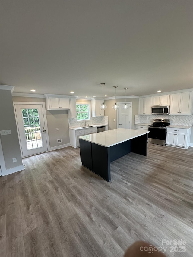 1133 Heather Oak Ln, Oakboro, NC 28129 - kitchen with appliances with stainless steel finishes, a center island, ornamental molding, light countertops, and recessed lighting