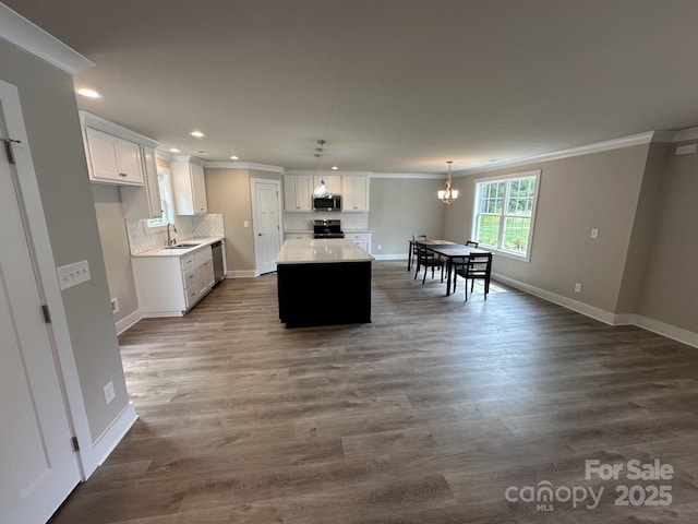 1133 Heather Oak Ln, Oakboro, NC 28129 - kitchen featuring appliances with stainless steel finishes, crown molding, recessed lighting, a center island, and decorative backsplash