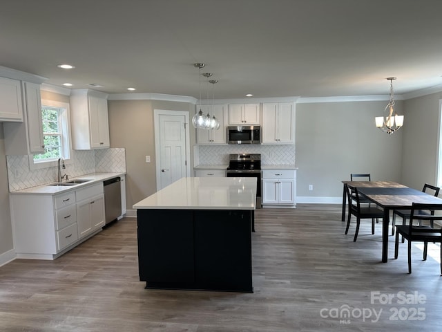 1133 Heather Oak Ln, Oakboro, NC 28129 - kitchen featuring stainless steel appliances, decorative backsplash, ornamental molding, a chandelier, and white cabinets