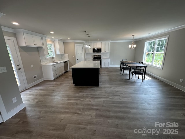 1133 Heather Oak Ln, Oakboro, NC 28129 - kitchen featuring appliances with stainless steel finishes, a chandelier, ornamental molding, backsplash, and white cabinetry