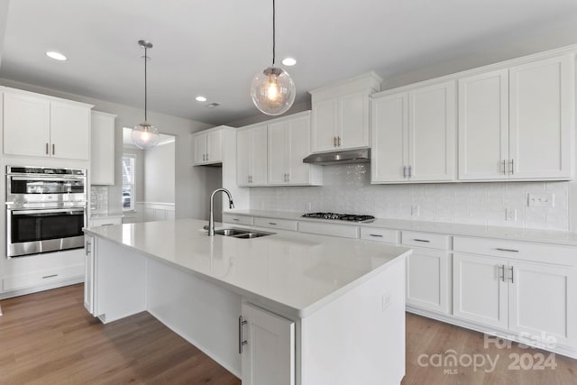 kitchen with pendant lighting, light wood-type flooring, white cabinetry, and sink