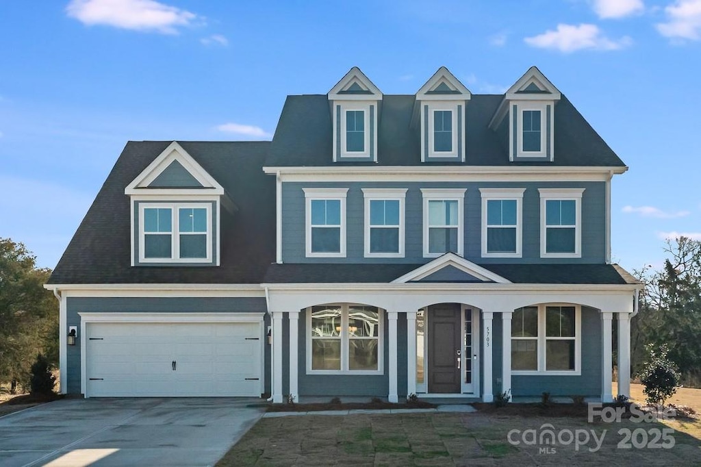 view of front facade featuring an attached garage, a porch, and concrete driveway